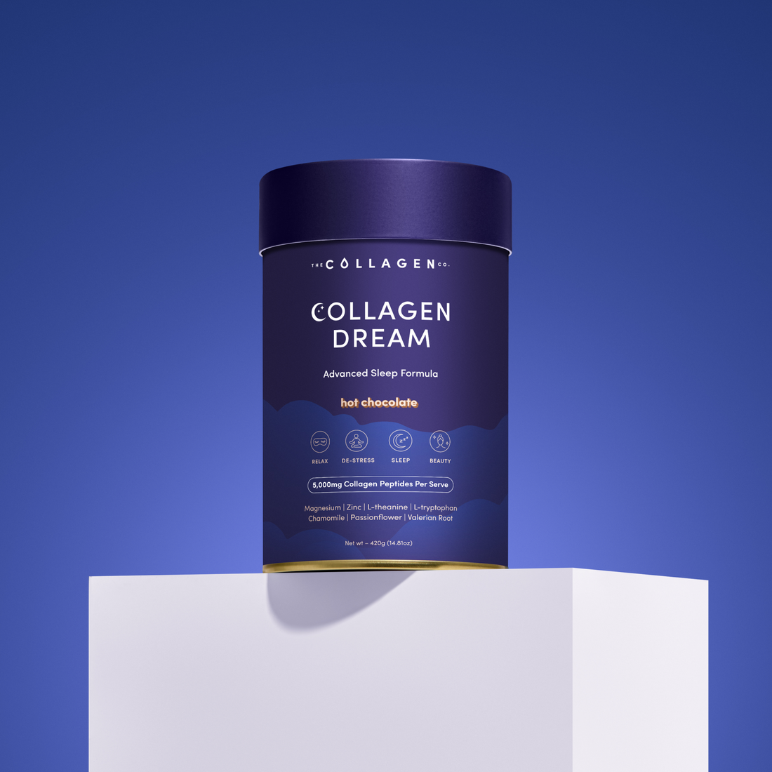 Collagen Dream Hot Chocolate tub on a white pedestal against a blue background. Front label highlights benefits like relaxation, sleep support, and 5,000mg of Collagen Peptides per serve.
